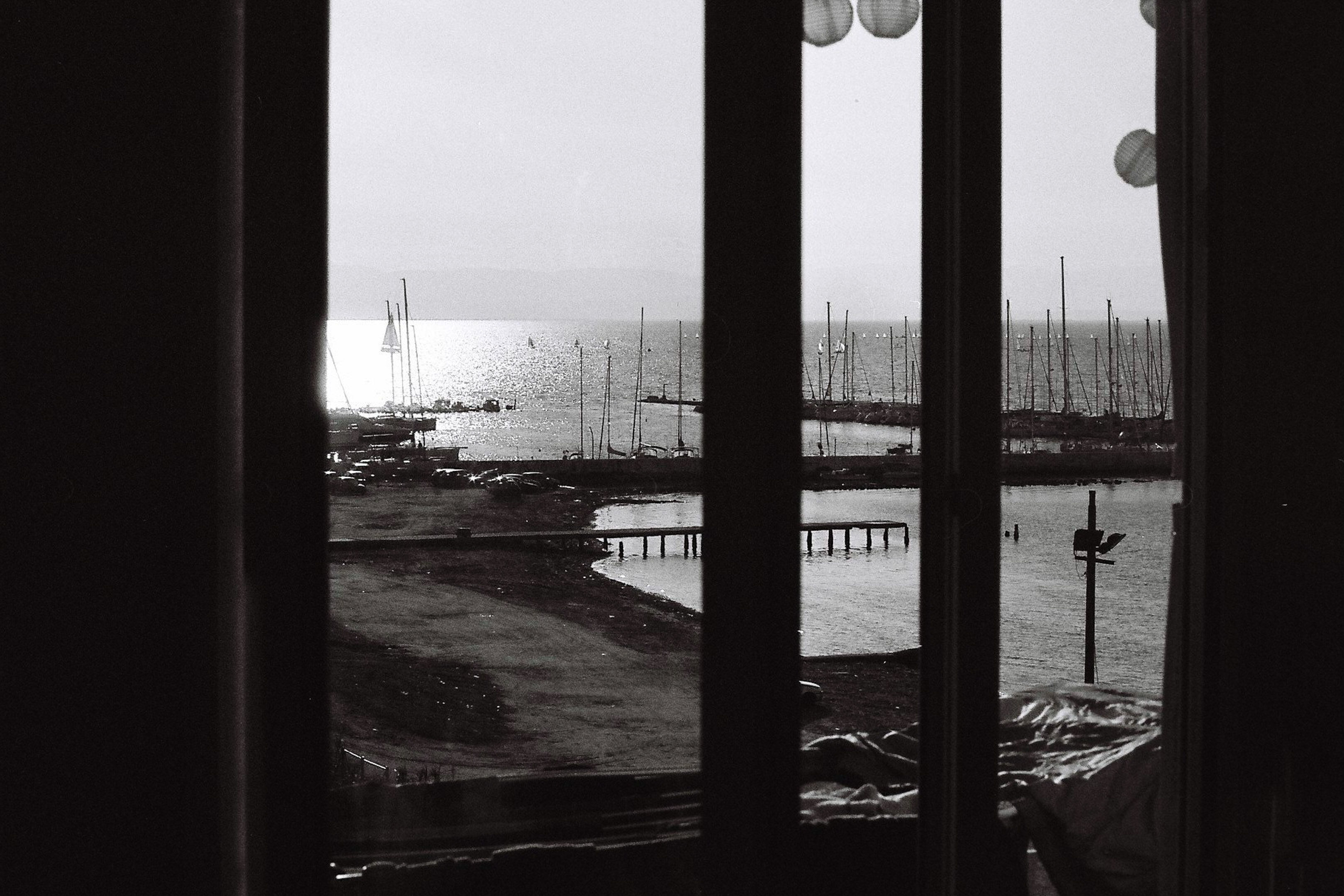 view towards the sea and sail boat in glittering sun