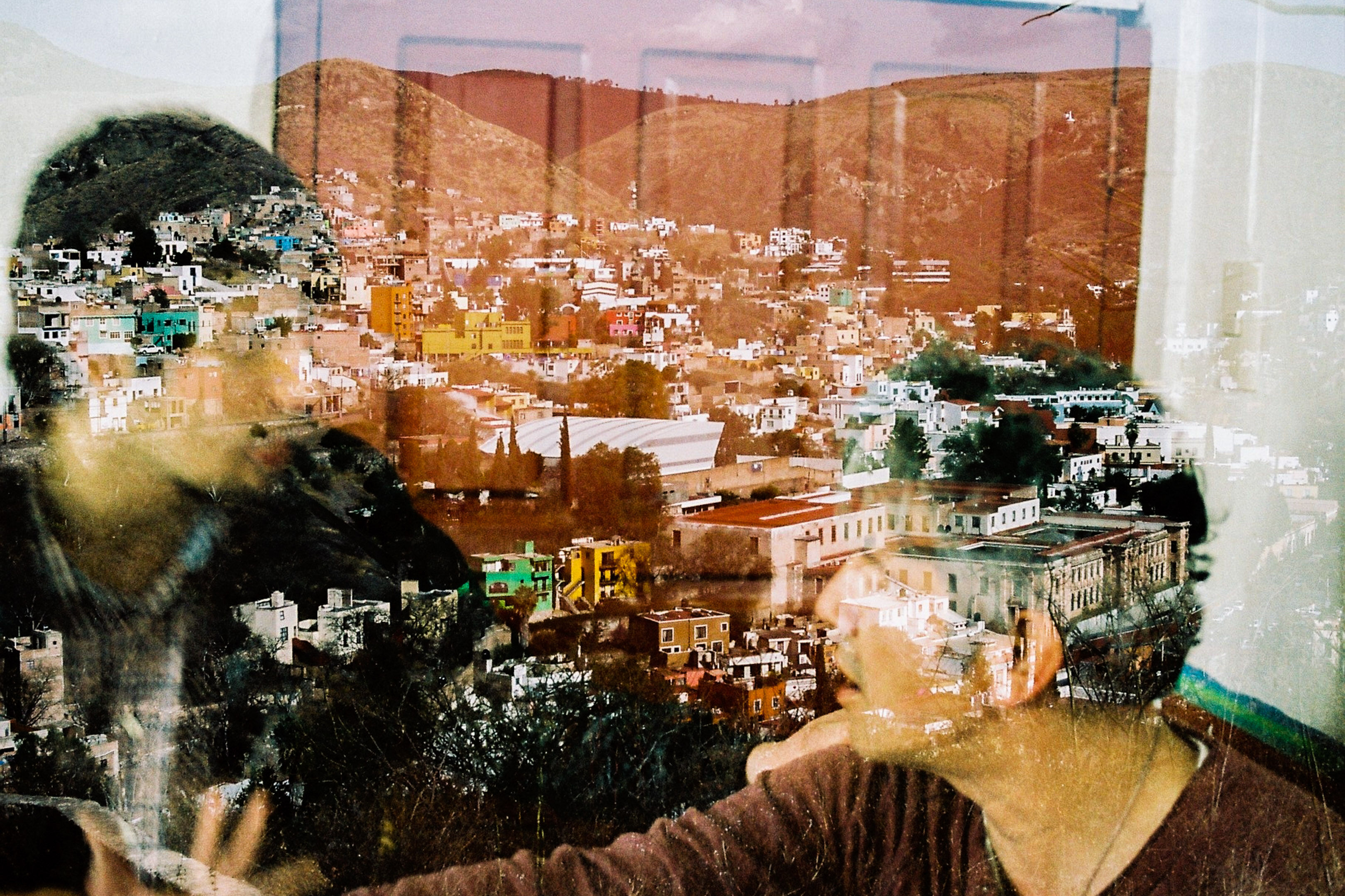 Double exposed image of two men talking and Guanajuato in the backround