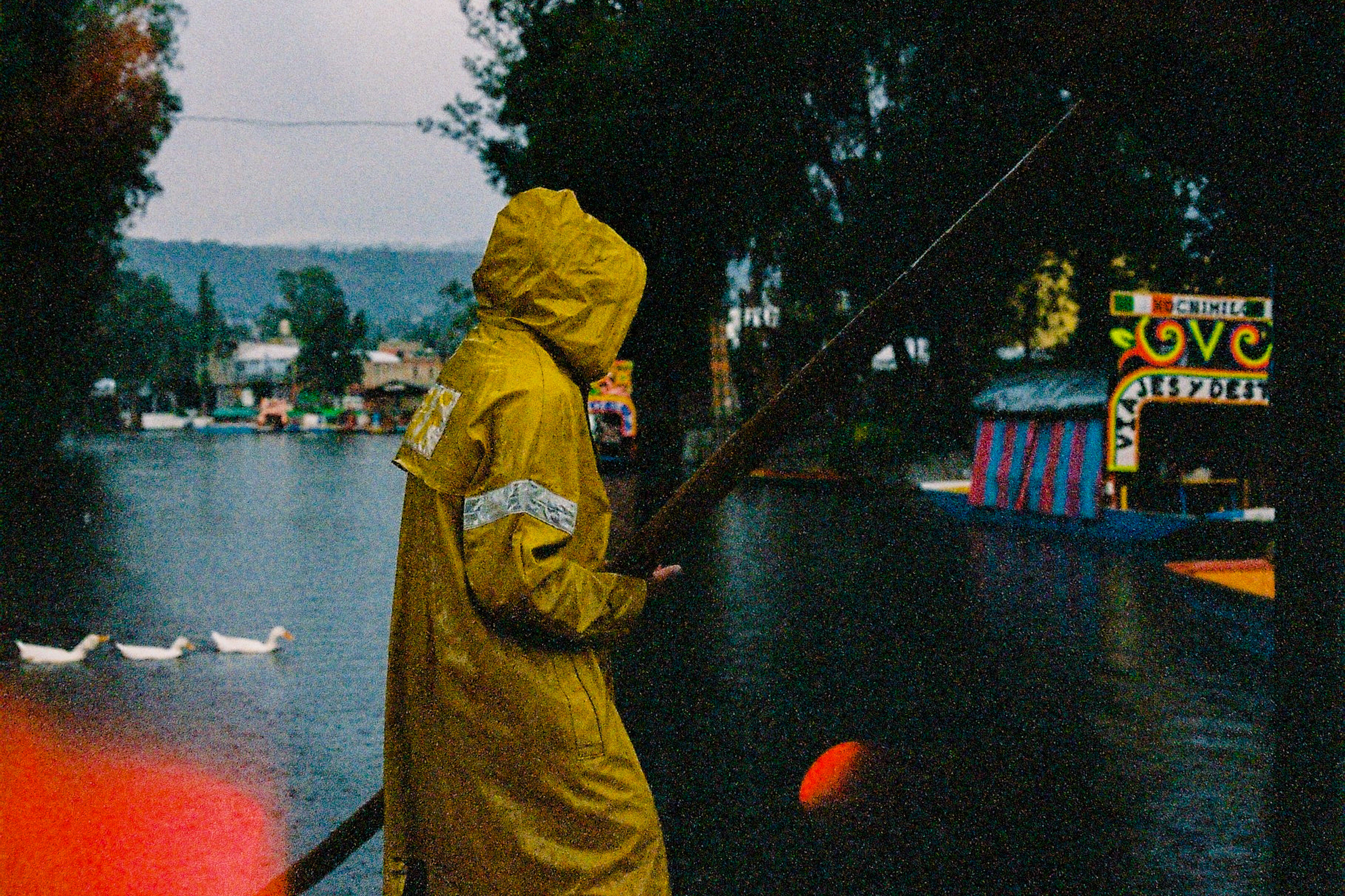 Gondolero in Xochimilco on a rainy day