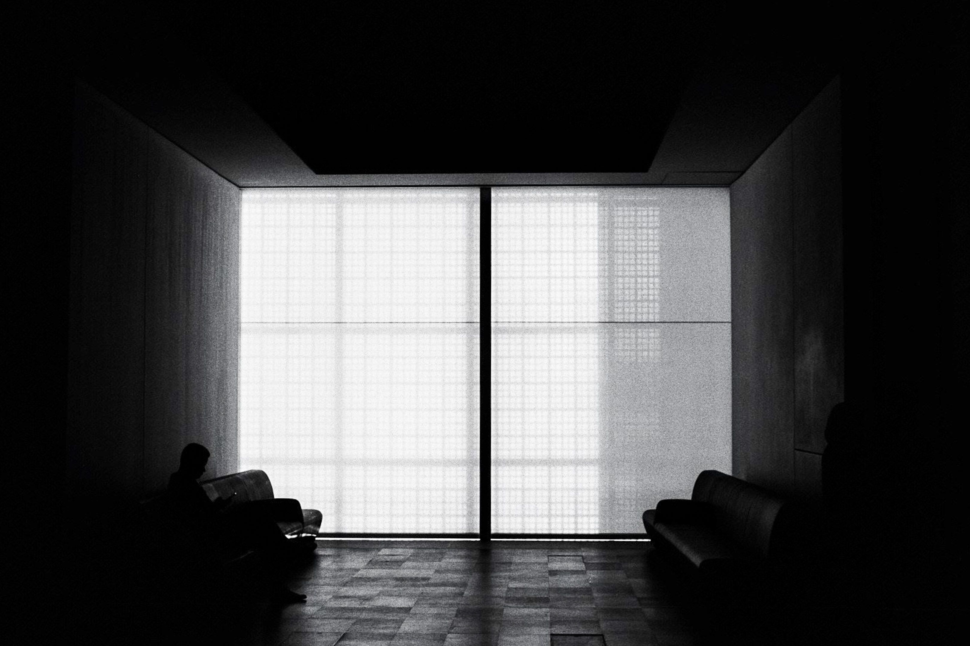 Man inside a room with grid shape window