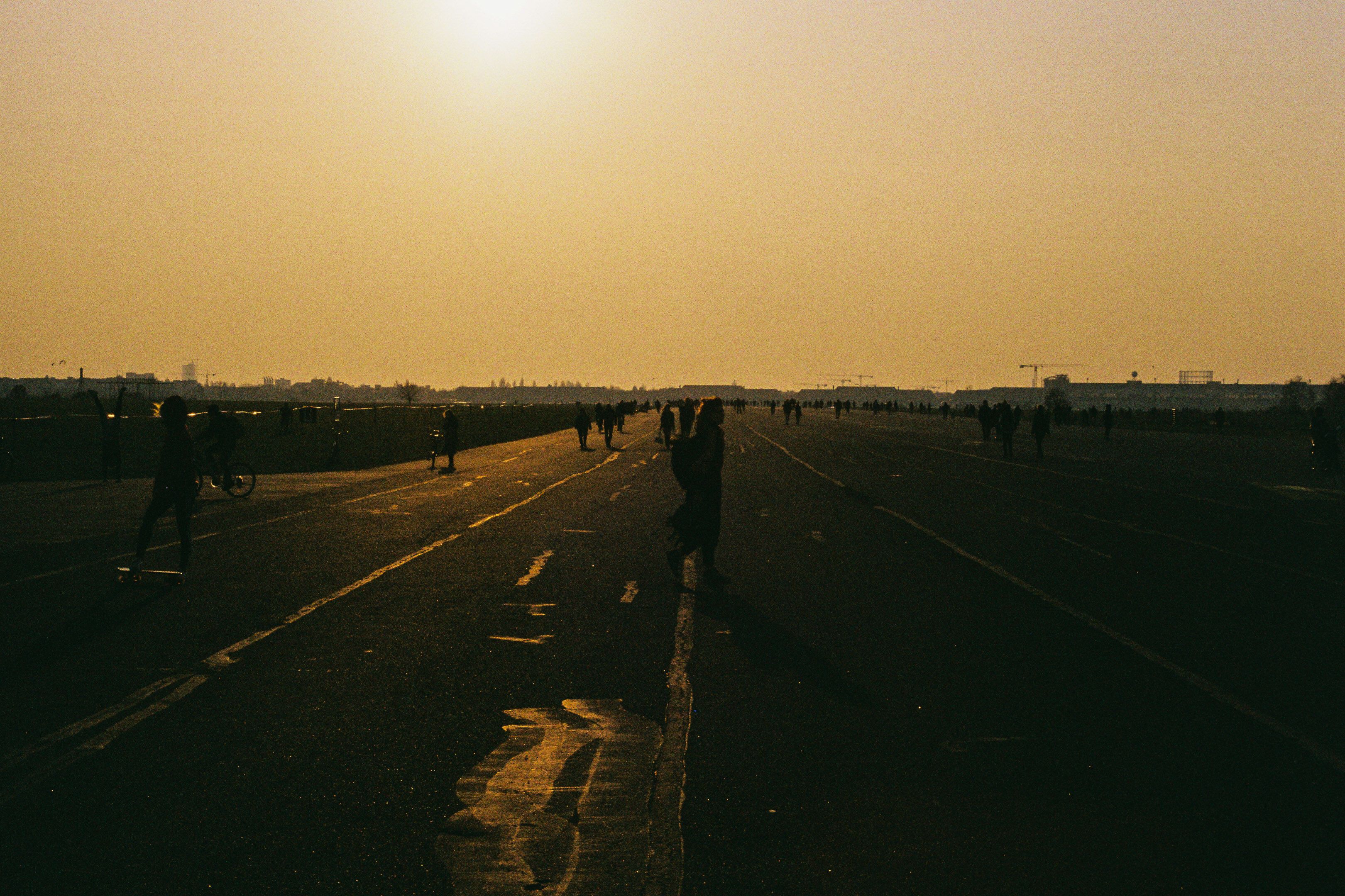 People on the airstrip in golden light at the Tempelhofer Feld