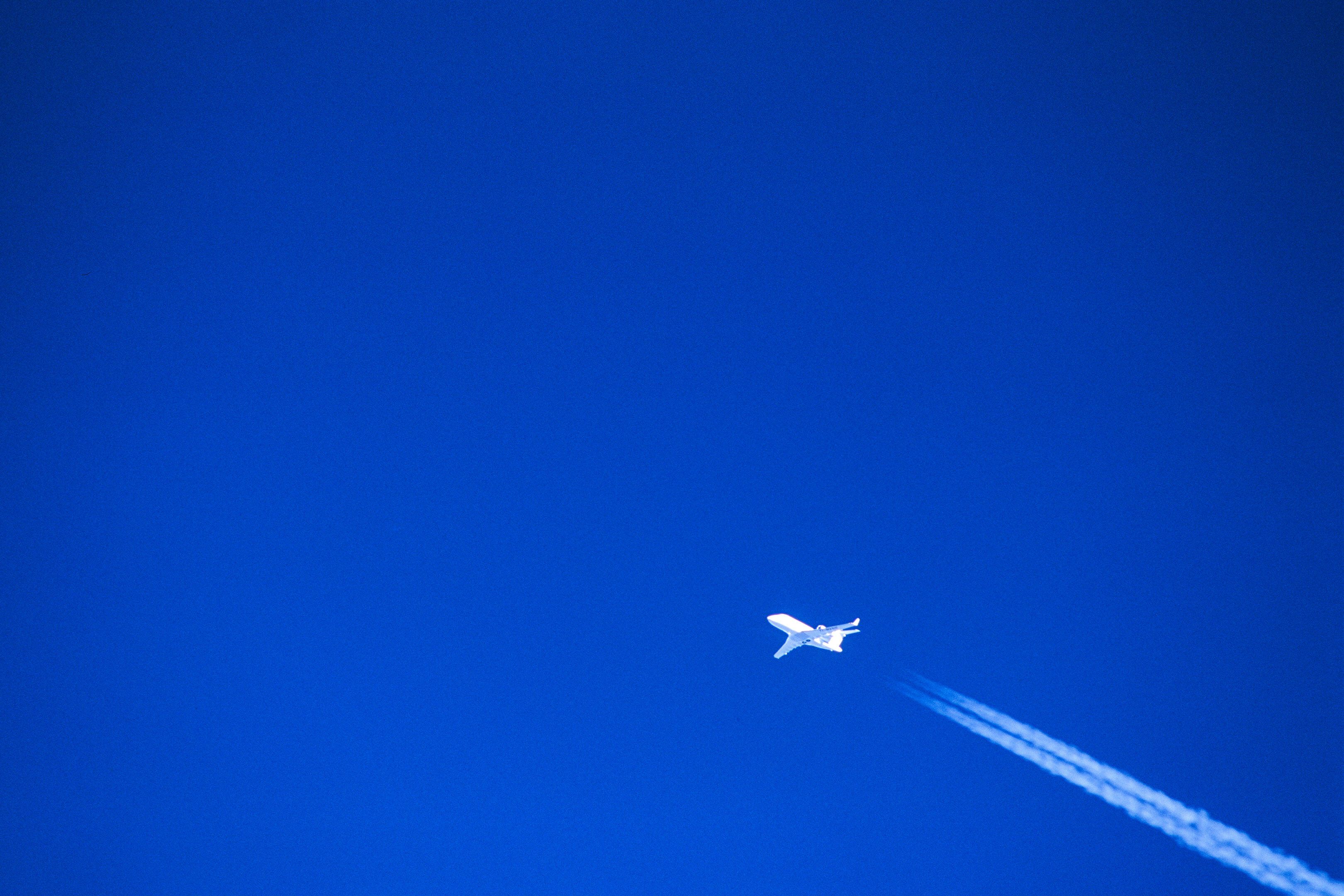 Airplane and contrail in the blue sky